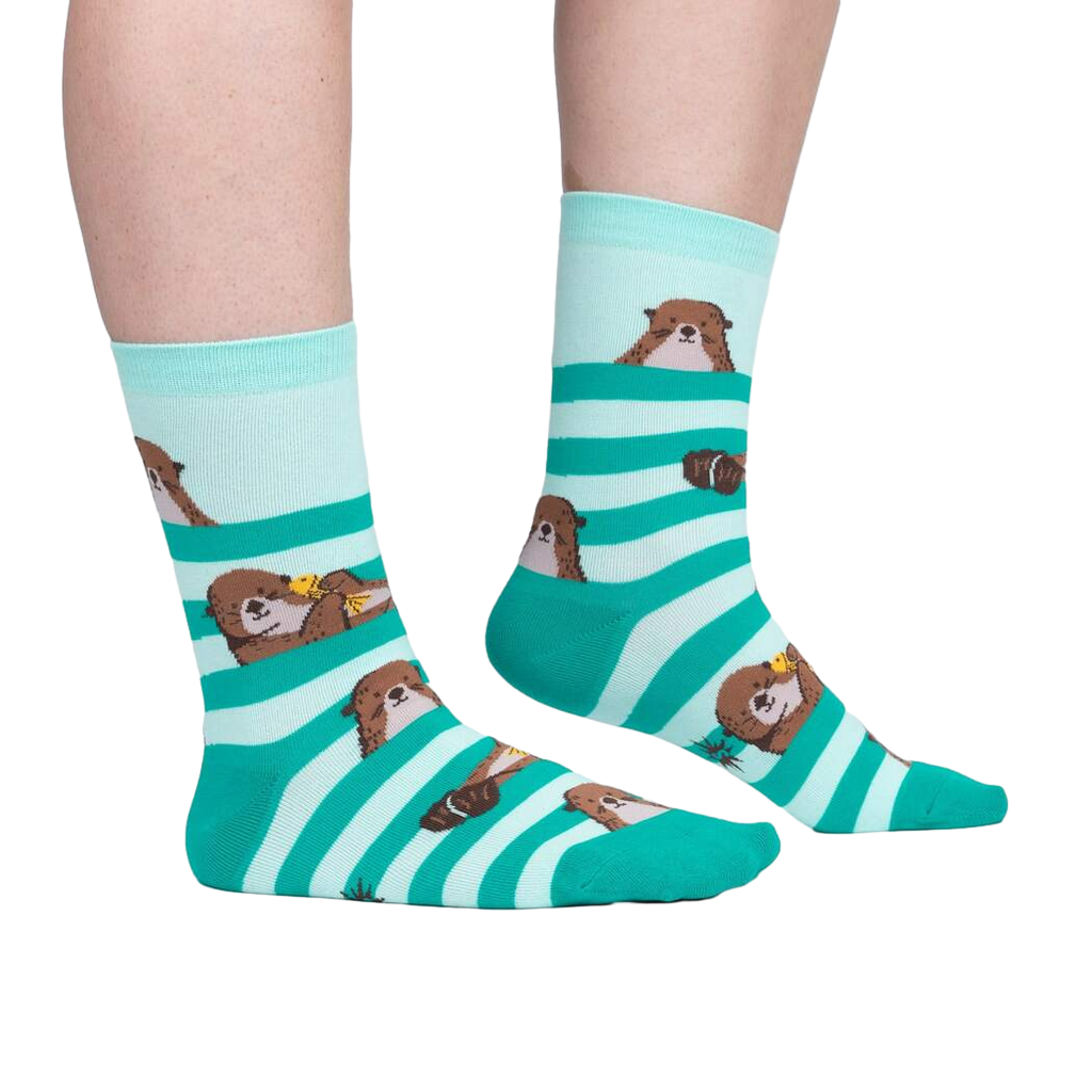 Teal and white striped socks with dog illustrations worn by a person on a white background