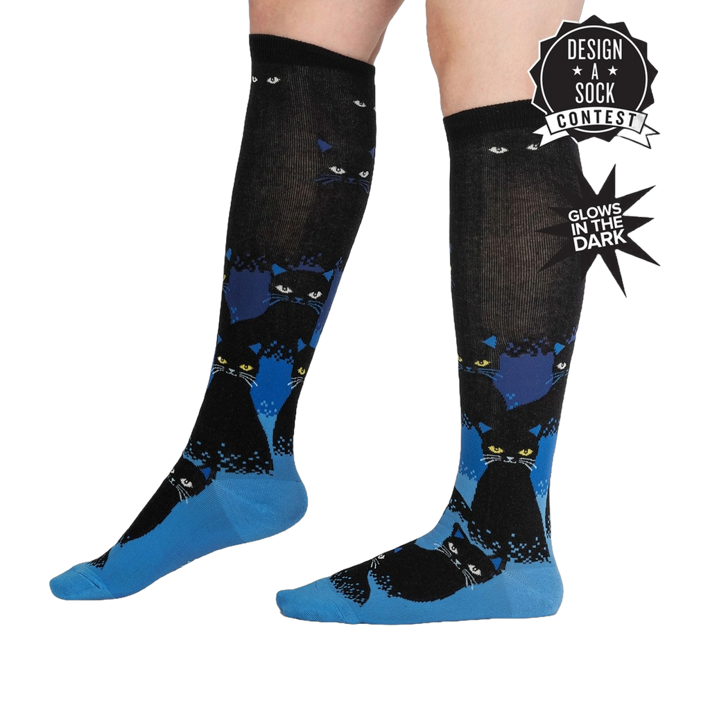 Knee-high socks with cat pattern glowing in the dark on a white background