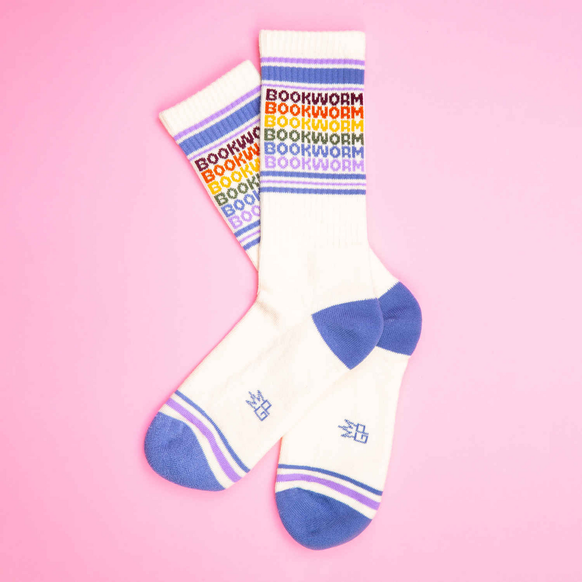 White socks with colorful 'bookworm' text and blue accents on a pink background