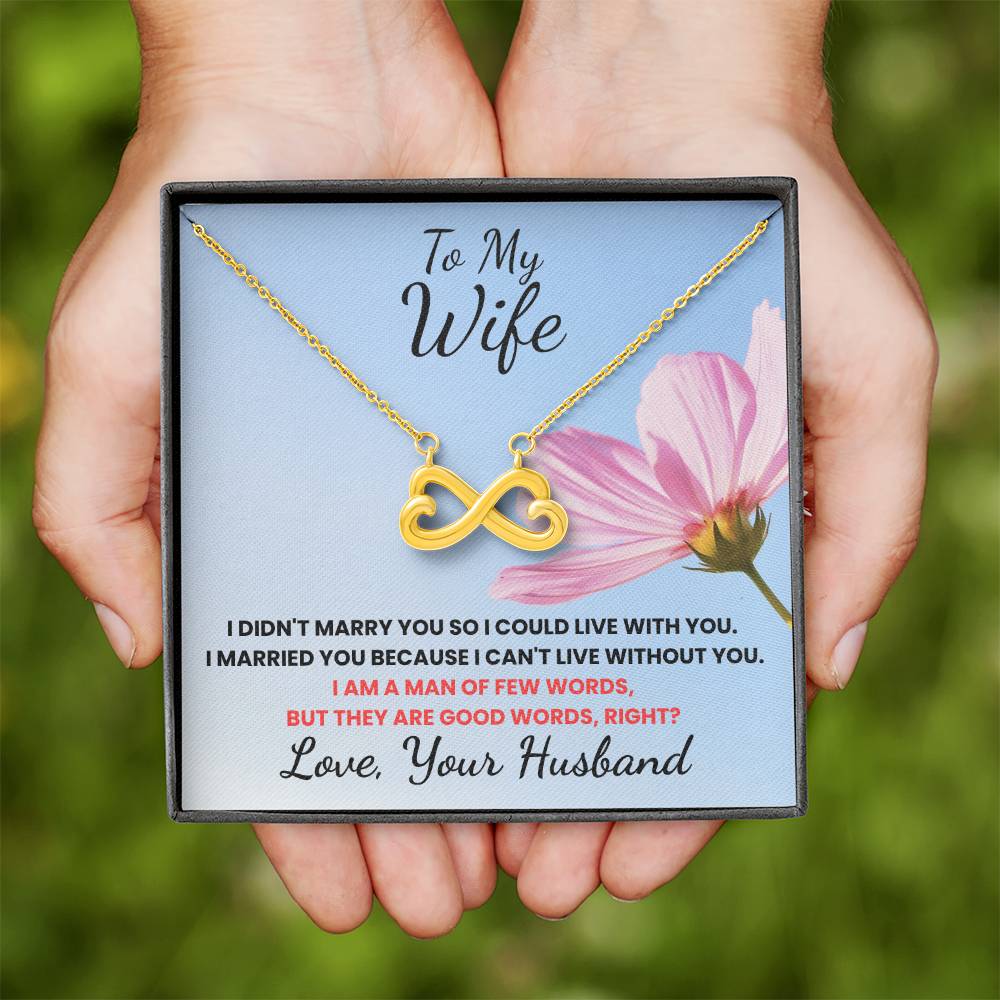 Necklace with a message card held by hands against a blurred green background