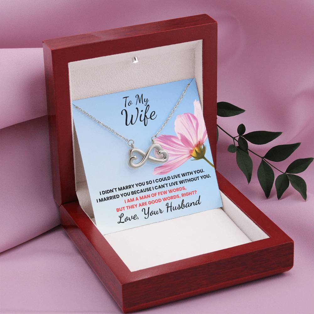 Necklace with a sentimental card in a red box on a pink background
