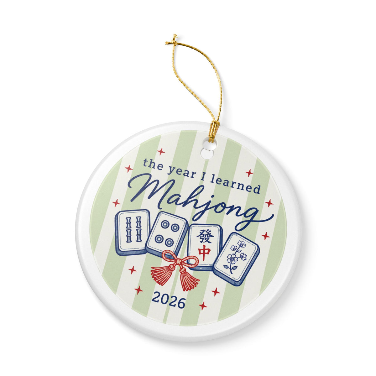 A round white ceramic Christmas ornament featuring a green and white striped background with illustrations of mahjong tiles, the text 'the year I learned Mahjong 2026', and a red bow. The ornament has a gold hanging string and is shown on a clean white background.