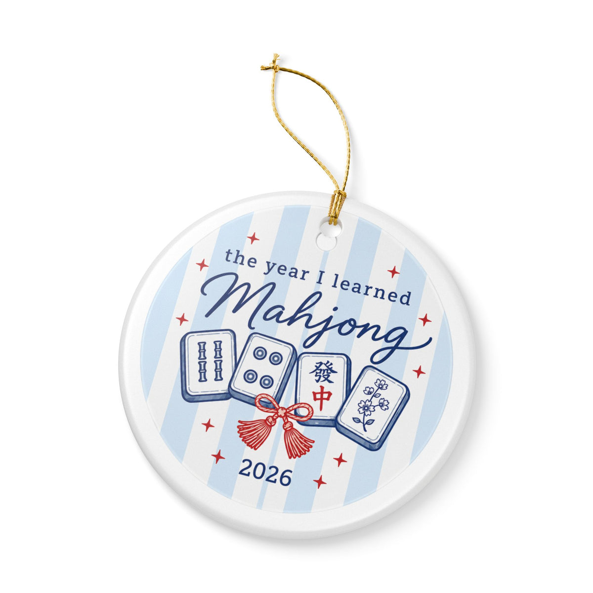 A round white ceramic ornament with a gold hanging string, featuring a blue and white striped background with illustrations of mahjong tiles, red stars, and the text 'the year I learned Mahjong 2026'.