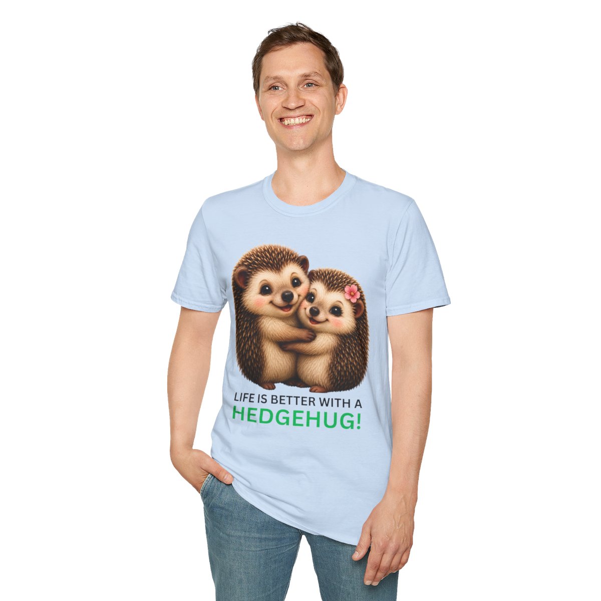 A man wearing a light blue crewneck t-shirt with a graphic of two hugging hedgehogs and the text 'LIFE IS BETTER WITH A HEDGEHUG!' in green and black, paired with blue jeans against a plain white background.