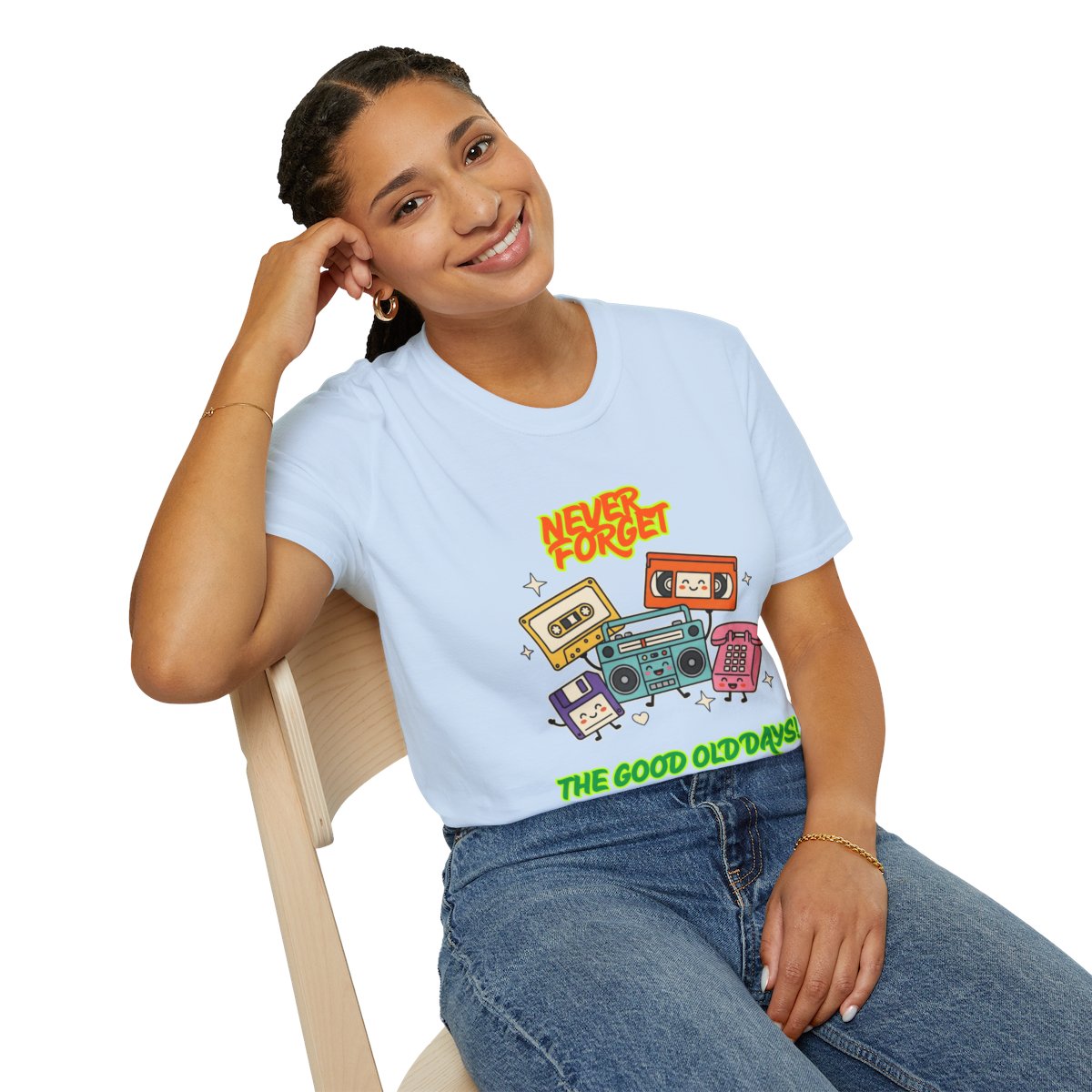 A woman sitting on a wooden chair wearing a light blue graphic t-shirt with retro cassette tapes and the text 'NEVER FORGET' and 'THE GOOD OLD DAYS'.
