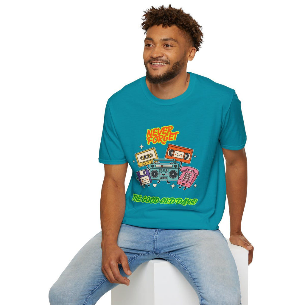 A man wearing a teal graphic t-shirt with retro cassette tapes and the text 'Kool Hercs' and 'THE GOOD OLD DAYS', paired with light blue jeans, sitting on a white block against a white background.