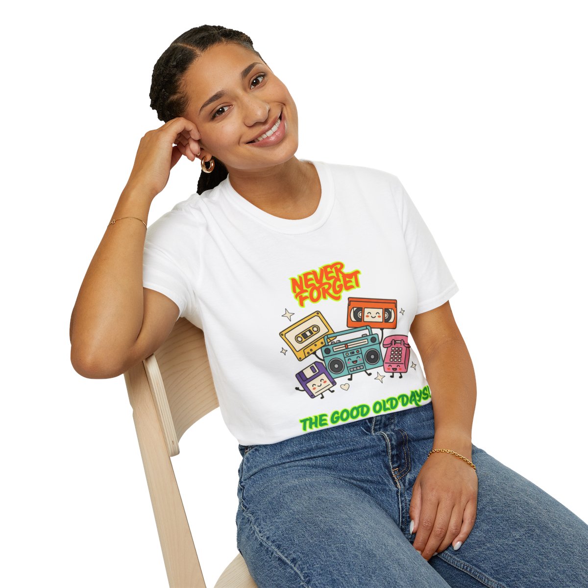 A woman sitting on a light wood chair wearing a white graphic t-shirt with retro cassette tapes and boomboxes, paired with blue jeans, against a solid white background.