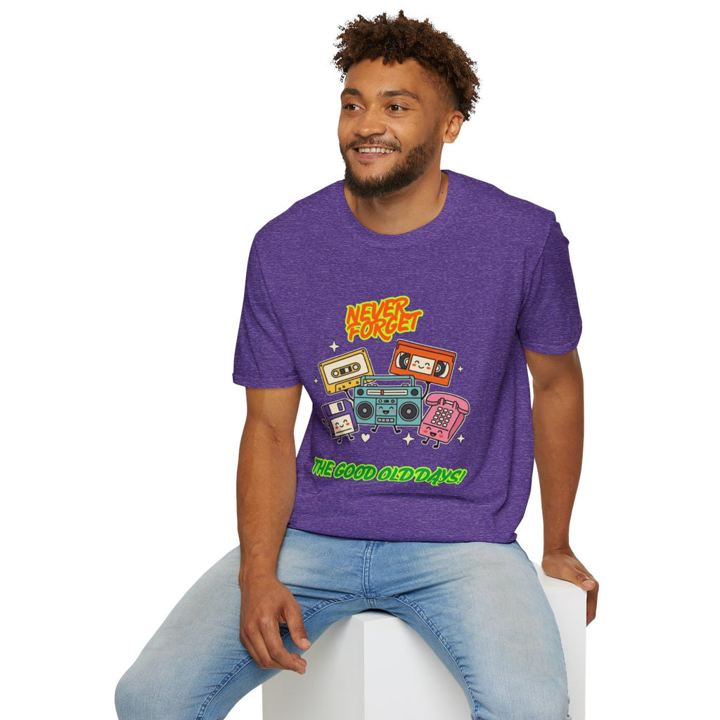 A man wearing a purple heather graphic t-shirt with retro cassette tapes and the text 'The Good Old Days', paired with light blue jeans, sitting on a white block against a white background.
