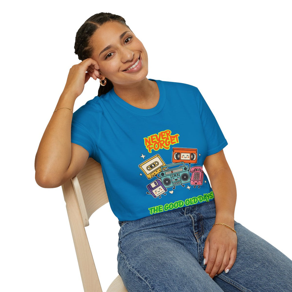 A woman wearing a bright blue graphic t-shirt with retro cassette tapes and boomboxes, sitting on a light wood chair against a white background.
